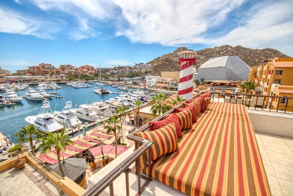 Stripe-cushioned daybed on the terrace overlooking the marina and yachts